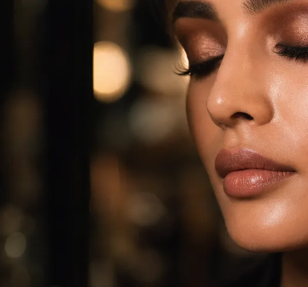 A close-up portrait showing a model's bronze eye makeup.